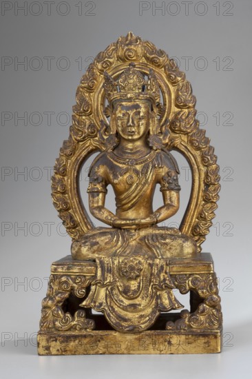 Amitayus, Tibetan Buddhist Sino-Tibetan style, Qing dynasty 1644–1911. Buddha of Infinite Life Amitayus seated in meditative pose with hands folded in a meditative gesture. Hair styled in a chignon with a high bun tied on top, hair colored blue; adorned with a five-leaf crown inlaid with semi-precious stones set on a headband mounted on the underside. Back painted orange. Missing: hair flowing to the shoulders, shoulder sash, stones, and earrings probably large, flower-shaped, falling on the shoulders. Bottom closed with a wooden plaque secured with metal pins and mortar; plaque bears a drawing of a quadruple vajra. Inscribed. Sculpture, 1770, China. Height 22.0 cm, width 11.5 cm, depth 8.9 cm., A gilded seated figure on a carved pedestal, with a decorative ornate halo behind the head; the figure wears a crown and has stylized curled hair, earrings, armlets, and draped garments, with hands resting in its lap; the pedestal and halo feature swirling floral and scroll motifs. The visible ...