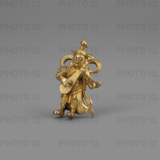 Dhrytarashtra;, Himalayan culture; Tibetan Buddhist art; Himalayan art; musical instrument; 2nd half of the 18th–19th century; possibly Mongolia, possibly Tibet; sculpture; figurine; cult object; height 3.4 cm, A small golden figurine of a seated person holding and playing a stringed instrument is centered against a plain gray background; the figure wears ornate clothing and headgear with flowing elements and curved decorative loops behind the head, and the visible colors are gold and shades of gray.