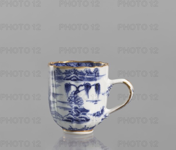 Cup, ceramics, blue-and-white porcelain, Qing style, landscape motifs, Chinese art, Qing 1644–1911, part of a 22-piece tea and coffee set including a teapot, 6 cups, 6 saucers, a bowl, a cover, and a plate, 19th century Qing dynasty, 1644–1912, China, vessel; height 6.5 cm, width 5.9 cm, diameter 5.9 cm., A small ceramic cup with a handle sits against a plain gray background; the cup is predominantly white with blue decorative painted scenes and motifs around its curved body, a gold rim around the top edge and gold accents on the handle and base, and the handle is white with gold trim.
