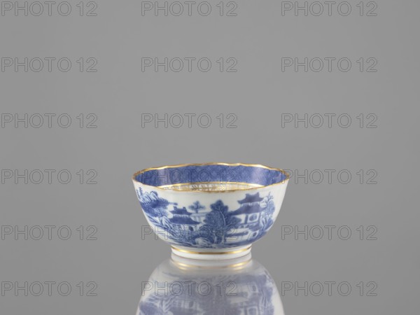 Teapot, ceramics, blue-and-white porcelain, Qing dynasty 19th century, 1644–1912, Chinese, landscape motifs; part of a 22-piece tea and coffee service teapot, 6 cups, 6 goblets, 6 saucers, a bowl, a cover, and a plate; vessel; height 7 cm, diameter 14.3 cm., A small porcelain bowl sits on a reflective surface, showing a blue and white exterior decorated with a scenic pattern and a blue interior with a subtle geometric design; the rim and a few bands near the base are accented in gold, and the background is a uniform gray.