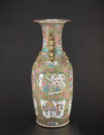 Vase attributed to an, Chinese, 19th century. Colored porcelain decorative vessel vase with figurative court scenes, butterflies, plant and floral ornaments; height 93.0 cm, diameter 34.0 cm., A tall decorative vase stands against a dark background, covered in dense, ornate painted scenes and floral patterns. The vase displays a palette of pink, green, gold, white, blue, and red, with gold-colored sculpted handles in the shape of stylized animal or mythical forms attached near the neck. The neck flares outward at the rim and is richly patterned with floral motifs and small figurative scenes, while the body shows framed panels containing groups of people, birds, and garden scenes surrounded by scrolling foliage and blossoms. The lower section continues the dense floral and geometric ornamentation, and the base has a narrow band of decorative motif. The overall surface is glossy and highly detailed with intricate brushwork and gilt accents.
