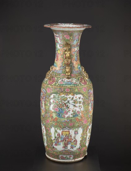 Vase, Chinese; figurative court scenes with butterflies, floral and plant ornaments; colored porcelain; 19th century, China; vessel; height 93 cm, diameter 34 cm., A tall decorative vase with an elongated neck and flared rim sits against a dark background; the vase is covered in intricate painted scenes and floral patterns in colors including green, pink, red, blue, gold, and white, with gilded ornamental handles shaped like stylized animal or mythical figures on the neck and shoulder; the body displays framed pictorial panels featuring groups of people in traditional dress and natural motifs with birds and flowers, surrounded by dense scrolling foliage and rosette designs; the rim and base edges are also decorated with patterned bands and floral motifs, and the overall surface shows a highly detailed, colorful enamel finish.