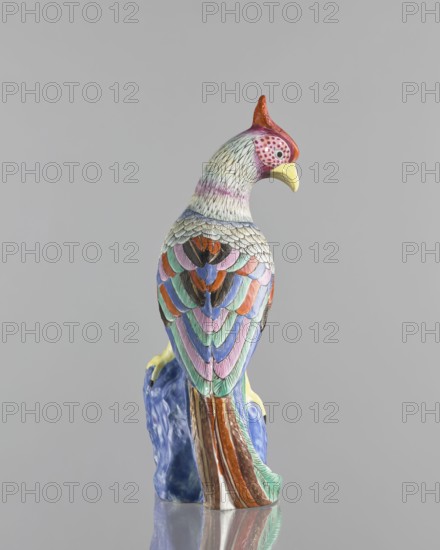 Rooster figurine, Chinese art, Chinese culture, Qing 1644–1911, ceramics, colored porcelain, animal figurine of a bird/rooster with rocks, 19th century, China, sculpture; height 28.5 cm, width 14.0 cm, A colorful ceramic bird sculpture perched on a textured base, showing a curved beak and a crest on its head, with layered stylized feathers in shades of pink, purple, blue, green, orange, brown, black, white, yellow, and red against a plain gray background.