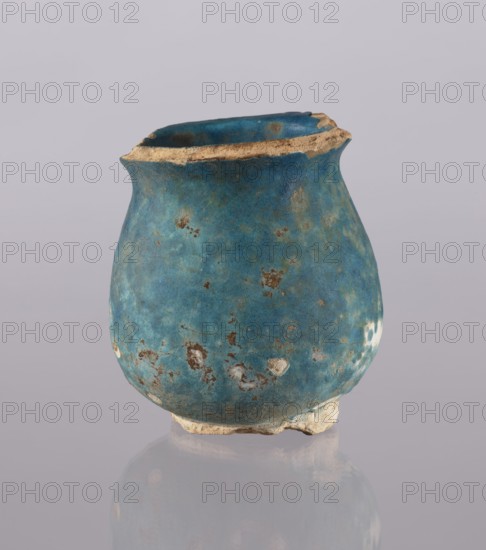 Jug, Abdullazad Mirza Baba fl. ante 1939, repossession noted, Islamic art, Persian culture, Ilkhanids 1256–1335, ceramics, vessel cup/vase, everyday life in the Middle East, 13th–14th century, Iran, weight 0.378 kg, height 12.5 cm, diameter 11.5 cm, A small rounded vessel with a worn rim sits against a plain pale background, its surface showing a rich blue-green patina with patches of lighter turquoise and areas of brownish corrosion; the rim and base reveal exposed beige material, and the vessel's exterior has several irregular spots where the blue finish has chipped away, creating a mottled texture and a slightly rough appearance.