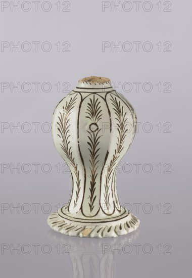 Bottle, Abdullazad Mirza Baba fl. ante 1939, Islamic art, Persian, Qajar dynasty 1785–1925; glazed ceramic bottle with fragments, diagonally knobbed foot edge; decoration in bronze lines and stylized feathery twigs; 19th century, Iran; vessel; height 19.0 cm, width 12.0 cm, A globular ceramic object with a flared base and a narrow neck, shown against a pale gray background; the piece is predominantly off-white with dark brown linear and leafy painted patterns arranged in vertical panels, and there are visible areas of light tan where the ceramic is exposed at the rim and a small chip on the base; the base has a scalloped edge and the object casts a soft reflection on the surface beneath it.