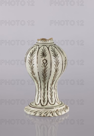 Bottle, Abdullazad Mirza Baba fl. ante 1939, Islamic art, Persian culture, Qajar dynasty 1785–1925, glazed ceramics, bottle with diagonally knobbed foot edge, decoration: bronze lines and stylized feathery twigs, 19th century, Iran, vessel, height 19.0 cm, width 12.0 cm, A pale off-white ceramic object with dark brown decorative vertical lines and leaf-like patterns, shaped with a rounded bulbous top narrowing into a slimmer middle and flaring into a ridged base, a chipped rim at the top showing a rough brown edge, a glossy surface creating a soft reflection on the pale lavender-gray background, with visible weathering and small brown spots on the glaze.