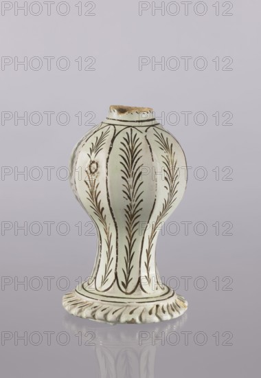 Bottle, Abdullazad Mirza Baba fl. ante 1939, Islamic art, Persian culture, Qajar dynasty 1785–1925, glazed ceramics, bottle fragment with diagonally knobbed foot edge; decoration: bronze lines and stylized feathery twigs; 19th century, Iran; vessel; height 19.0 cm, width 12.0 cm, A bulbous ceramic object with a flared base stands against a pale background; the object is primarily off-white with brown linear decorative motifs resembling vertical plant-like fronds repeated around its rounded body and neck, and the rim is chipped showing an exposed rough brown interior. The base has a scalloped edge with brown detailing and the surface shows a glossy finish with a subtle reflection beneath it. The visible colors are off-white, brown, and a hint of beige in the exposed chipped area, set against a very light grayish-lavender background.