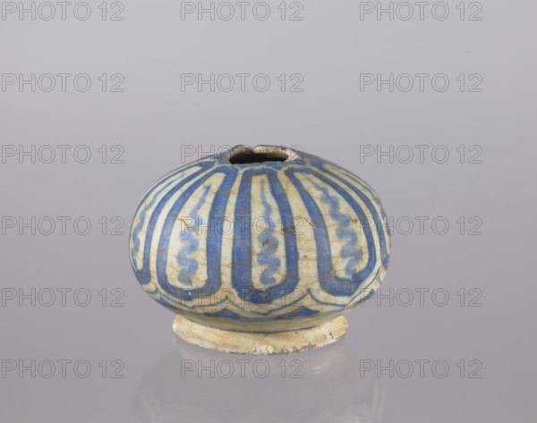 Bottle belly, glazed ceramic bottle, utility vessel decorated with cicadas, Persian Islamic art, 18th century, Iran; height 10.2 cm, diameter 14.1 cm., A small rounded ceramic vessel with a short foot and a narrow irregular opening, decorated with a repeating vertical pattern in blue on a pale cream background, showing areas of wear and slight discoloration; the surface has visible crackle and some brownish spots, and the object sits on a reflective pale gray surface against a soft light gray background.