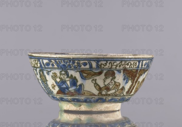 Bowl, Abdullazad Mirza Baba fl. ante 1939, Qajar dynasty 1785–1925, 2nd half of the 19th century, Iran. Glazed ceramic vessel tableware, height 7.5 cm, diameter 17.4 cm. Decoration: knightly and figurative scenes with horses and falcons; rims decorated with figures, architecture, flowers, animals, palmettes, and inscriptions. Styles/subjects: Islamic art; Persian art; ceramics., A shallow ceramic bowl with a rounded rim sits against a muted gray background, decorated around its exterior with painted figurative scenes and floral motifs in blue, green, brown, and cream tones; a band of blue decorative shapes runs beneath the rim, and a border of similar blue elements encircles the lower edge above a foot with mottled green and cream glazing, while the painted figures and surrounding foliage display blue clothing and brown hair and accents, all set on a cream-colored ground.