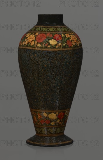 Vase, Qajar dynasty 1785–1925, Persian, 19th century, lacquer vase. Decoration: densely placed plant motifs peonies with gold contouring; collar and above the foot decorated with flowers red and gold. Inscription Italian on inner card noting it is a lacquer vase. Vessel; height 32.0 cm, diameter 17.0 cm., A tall vase with a rounded body tapering to a narrower foot, decorated with floral bands and a dark central field; the top and lower bands show a group of stylized flowers in red, yellow, orange, green, and hints of blue against a dark background, separated by narrow goldish borders; the central area is predominantly dark with an embossed or painted pattern of flowers in deep blue and muted gold tones creating a textured appearance; the neck and base rim are dark, with touches of goldish trim, and the overall color palette includes black, dark blue, green, red, yellow, orange, and goldish accents.