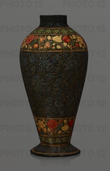Vase, Qajar dynasty 1785–1925, Persian, Islamic art; lacquer vase, 19th century, Iran. Vessel, height 32.0 cm, diameter 17.0 cm. Decoration: densely placed plant motifs peonies with gold contouring; on the collar and above the foot flowers red and gold. Inside a card no. 54 with an inscription in Italian noting it is a lacquer vase., A tall vase with a rounded body tapering to a narrow base and flared foot is shown against a neutral gray background; the vase has a glossy dark surface with decorative bands featuring floral motifs, including a band near the top and one near the base with painted flowers in red, yellow, green, and orange set against darker backgrounds, and the main central area is densely decorated with carved or painted floral patterns in deep blue and muted gold tones, with touches of green and brown visible on the neck and foot.