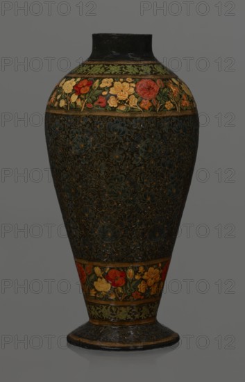 Vase, Qajar dynasty 1785–1925, Persian, Islamic art; lacquer vase, 19th century, Iran; vessel, height 32.0 cm, diameter 17.0 cm. Decoration: densely placed plant motifs peonies with gold contouring; on the collar and above the foot flowers red and gold. Inside a card no. 54 with an inscription in Italian noting it is a lacquer vase., classification/role of the creator not recorded., A tall vase with a rounded shoulder and narrow base stands against a plain background; the vase has a dark overall color with an intricate floral pattern etched or painted across most of its body in deep blue and dark green tones, accented with small touches of gold; near the top and above the base there are decorative bands featuring a floral motif in brighter colors including red, yellow, orange, green, and a few pale cream tones; the neck and rim of the vase are a solid dark color, and the base has a slightly glossy dark finish with thin gold-colored edging.