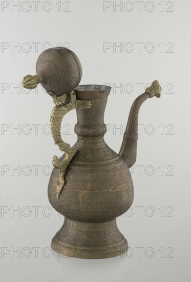 Jug aftabe, Persian, Qajar dynasty 1785–1925, aftabe; dense plant and geometric ornament; dragons, zoomorphism; 19th century; Central Asia, Iran ; ceramic vessel; height 34.0 cm, width 22.7 cm, diameter 13.3 cm., An ornate metal ewer with a rounded body on a flared base, showing intricate raised and engraved patterns across its surface in muted brown and bronze tones with areas of darker patina; a tall neck leads to a flared rim and a curved spout extending outward, both decorated with the same patterned motifs; a hinged domed lid with embossed decoration sits beside the rim, attached to a decorative handle that arches from the rim to the body, the handle and lid fittings showing a contrasting aged yellowish-gold color; the background is a smooth, very light gray that creates a subtle reflection beneath the object.