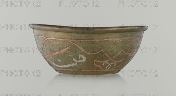 Bowl, Islamic art, Arabic culture, arabesque ornament, calligraphy, Arabic inscriptions, geometric motifs, inscriptions, 19th century, Middle East, possibly Syria, vessel, height 4.9 cm, diameter 13.3 cm, A shallow bowl with a rounded base and a slightly flared rim sits against a pale background; the bowl appears metallic with an overall brass-like color and features decorative inlaid or raised patterns in a pinkish copper tone and areas of pale off-white; the surface shows textured areas with small repeating dimples and smoother bands, and the rim has a subtle raised lip with a darker edge; the decorative motifs include flowing, curving lines and abstract shapes that wrap around the body of the bowl, and the bowl rests on a reflective surface that produces a faint mirrored patch beneath it.