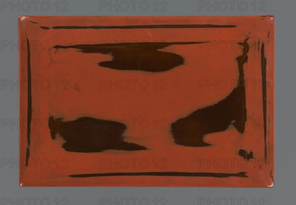 Box with lid; maker, gift; Japanese art; Japanese; Meiji 1868–1912; negoro; early 20th century Meiji period; Japan; container; height 2.6 cm; width 16.2 cm; depth 10.8 cm, A rectangular flat surface with a dominant orange-red color and a matte appearance, showing several irregular dark brown patches and streaks across its center and edges, a narrow dark brown border line near the perimeter on all sides, subtle smudges and worn areas where the orange-red is thinner, slightly rounded corners with small highlights, and a neutral gray background surrounding the rectangle.