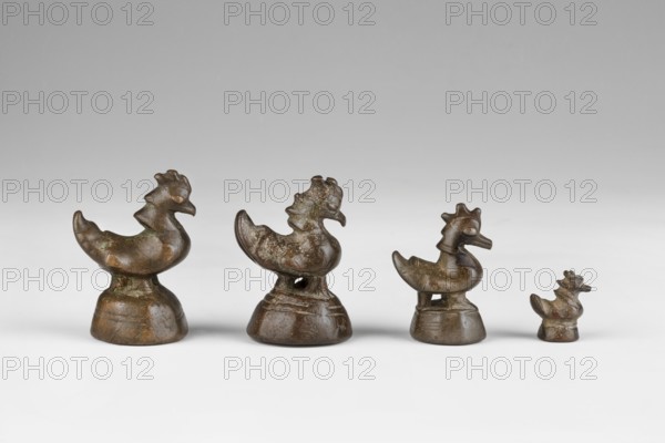 Karaweik bird-shaped weight, weighing 5 tikals; maker, 2nd half of the 19th century; Burma Myanmar; Southeast Asian/Burmese art; metal weight on a hexagonal base, the base marked with a drawing of a bird on the right; height 4.35 cm; weight 75.9 g., A row of small sculpted bird figures made of a brownish metal, arranged from larger to smaller on a light gray surface against a soft gray background; each figure has a rounded body, a stylized head with crest-like features, and sits on a rounded base, with visible surface patina showing darker brown and some greenish spots.