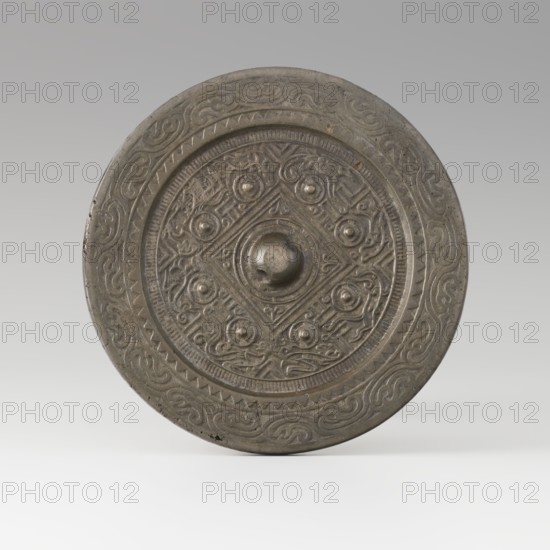 Mirror with TLV decoration on a pedestal in the form of a qilin on a base. Chinese, Qing dynasty 1644–1911. Materials: cast and chiseled bronze mirror with TLV flat-relief decoration—centrally placed knob enclosed in a square with four T-like motifs and L- and V-shaped motifs at the edge; unicorn qilin cast from chiseled bronze; carved wooden base. 18th century mirror cast from an earlier product, possibly 6th century–?. Sculpture/mirror. Height 26 cm; diameter 16.2 cm., A circular metal object with a raised central boss and concentric decorative bands, showing a patina of gray and dark gray tones with areas of brownish discoloration; the central area features a geometric motif with a diamond shape and a group of raised rounded knobs surrounded by intricate repeating scrollwork and curvilinear designs; the outer band contains a repeating wave-like pattern and a zigzag border, all rendered in muted metallic gray and darker shadowed gray, set against a pale gray gradient background.