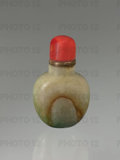 Snuffbox with spoon, Chinese, Qing dynasty 1644–1911, 19th century, moon bottle form, vessel, height 7.5 cm, width 4.5 cm, depth 2.8 cm., A small rounded bottle with a smooth, mottled surface in shades of pale green, beige, brown, and darker green, topped by a bright red cap with a slightly rounded top and a narrow metallic band beneath the cap; the background is a uniform gray and the bottle casts a soft reflection on a glossy surface below.