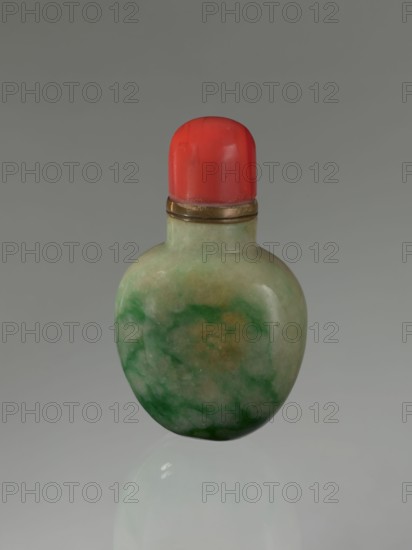 Snuffbox with spoon, Chinese, Qing dynasty 1644–1911, 19th century, moon bottle form, vessel, height 7.5 cm, width 4.5 cm, depth 2.8 cm., A small rounded bottle with a smooth, polished surface showing marbled shades of light green, darker green, and pale beige, topped by a bright red cap with a glossy finish and a thin metallic band between the cap and the bottle, all set against a neutral gray background.