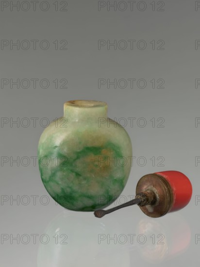 Snuffbox with spoon, maker, Chinese moon bottle, Qing dynasty 1644–1911, 19th century; material: Chinese; function: vessel/snuffbox; dimensions: height 7.5 cm, width 4.5 cm, depth 2.8 cm., A small rounded bottle with a short neck displaying mottled shades of green, pale green, and tan sits next to a separate stopper-like object with a red cap, a metallic brown circular base, and a dark thin metal rod extending from it; all objects rest on a reflective pale gray surface against a smooth gray background.