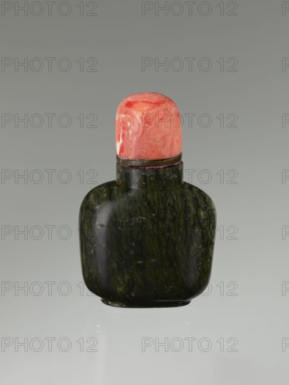 Snuffbox with spoon, Chinese, Qing dynasty 1644–1911, 19th century. Moon bottle plug stone: rhodochrosite. Vessel; height 7.1 cm, width 4.6 cm, depth 2.6 cm., A small rounded bottle with a dark green, mottled stone body and a glossy surface is topped by a bulbous cap in swirled shades of coral, pink, and pale orange; a thin dark band separates the cap from the bottle, and the object sits against a smooth gray background with a faint reflection below.