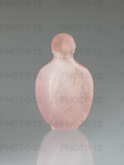 Snuffbox with spoon, decorated with flowers and dragonflies, Chinese art, Chinese culture, Qing dynasty 1644–1911, 19th century, China, vessel; height 7.4 cm, width 4.4 cm, depth 2.5 cm, A translucent pink glass bottle with a rounded stopper sits upright against a gray background, showing a smooth glossy surface and faint carved floral motifs on its front; the bottle has a slightly flattened oval shape with a narrow neck and a visible crack on one side, and it casts a subtle reflection on the pale surface beneath it.