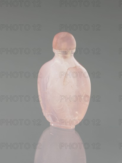 Snuffbox with spoon, flowers, dragonflies, Chinese art, Chinese culture, Kawenoki-Minc, Qing 1644–1911, 19th century, China, vessel; height 7.4 cm, width 4.4 cm, depth 2.5 cm, A small translucent bottle with a rounded stopper, both made of pale pink material, stands upright against a neutral gray background, showing a smooth glossy surface with a few cloudy inclusions and subtle carved or etched floral motifs on its body, and a soft reflection of the bottle visible on the surface beneath it.