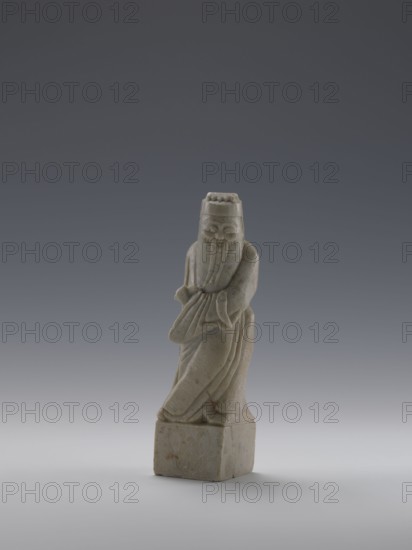Sage, figurine, men, Chinese art, Chinese culture, Qing 1644–1911, 19th century, China, sculpture; height 16.8 cm, width 4.6 cm, depth 4.3 cm., A small carved figure made of pale gray stone with subtle brownish spots stands on a square base, depicting an elderly person wearing a long flowing robe and a rounded hat; the figure has a long beard draped down the front, folded arms, and a serene facial expression, all set against a smooth gradient background shifting from dark gray at the top to lighter gray near the bottom.