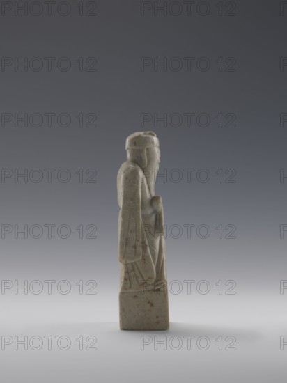 Sage, figurine, men, Chinese art, Chinese culture, Qing 1644–1911, 19th century, China, sculpture; height 16.8 cm, width 4.6 cm, depth 4.3 cm., A carved stone figure stands on a rectangular base, shown in profile facing right, with a long robe and a hat; the figure has a beard and holds an object near its torso. The stone is mostly pale gray with subtle greenish tones and small areas of reddish-brown spotting, set against a gradient background ranging from dark gray at the top to lighter gray near the bottom.