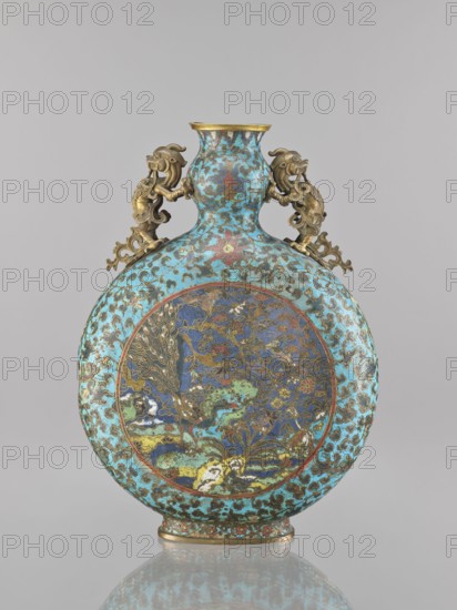 Vase - moon bottle pilgrim with a sleeve, cloisonné enamel, Qing 1644–1911, 19th century, China, decorated with peacocks, moon bottles, herons, dragons, flower tendril and lotus tendril ornament, vessel, height 39.3 cm, width 28.5 cm, depth 11.4 cm, A round flask-shaped vessel with a flattened circular body and a short neck, decorated overall in turquoise blue with darker blue and green cloudlike patterns, featuring a central round panel on the body that contains intricate multicolored enamel designs in deep blue, green, yellow, red, and gold tones depicting stylized natural motifs; the neck and shoulder share the turquoise and dark blue patterning, and there are a pair of ornate sculpted handles in a gold-colored metal shaped like stylized mythical creatures attached to the shoulder; the rim and the flat base have gold-colored metal accents, and the object sits on a reflective neutral-gray surface against a pale gray background.