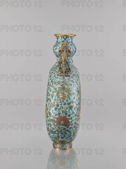 Vase - moon bottle pilgrim with a sleeve, peacocks, moon bottles, herons iconography, Chinese art, Chinese culture, cloisonné enamel, Qing 1644–1911, dragons iconography, flower tendril, lotus tendril ornament, 19th century, China, vessel, height 39.3 cm, width 28.5 cm, depth 11.4 cm, A tall, slender double-gourd shaped vase stands against a neutral gray background, its surface covered in an ornate swirling pattern with predominant turquoise and blue tones accented by areas of gold, brown, red, and green; the neck and base have metallic gold rims, and an applied decorative element in a brass or bronze tone is attached near the upper section, while the vase casts a faint reflection on the glossy surface beneath it.