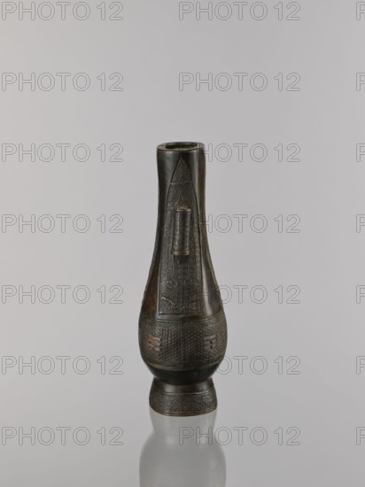 Hu-type vase, cicadas, Chinese, hu vessel, vases, Qing 1644–1911, ritual vessel, waves iconography, asanoha pattern, leiwen ornament, meander ornament, 19th century, China, vessel; height 22.1 cm, width 10.3 cm, depth 7.5 cm., A single tall vase-like object stands upright against a neutral light gray background and reflective surface, exhibiting a dark brown to black patina with subtle warm brown highlights; its elongated neck tapers into a bulbous midsection and narrows again toward a flared foot, and the surface shows carved and incised geometric patterns and raised decorative bands creating textured panels around the body, with a smooth rim at the top and a faint reflection of the object visible on the glossy surface below.