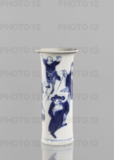 Flute-type vase, figurative scenes, ceramics, Chinese art, blue and white porcelain, Chinese, musicians, stars, 17th century Kangxi period, 1662–1722, Qing dynasty, China, vessel, height 12 cm, diameter 5.6 cm, A tall cylindrical ceramic vessel with a flared rim stands against a plain light gray background, decorated in blue on a white ground with stylized human figures in various poses; one figure near the top appears to have arms raised, another lower figure wears a dark robe and holds an object, and parts of additional figures are visible around the sides. The surface shows a glossy finish and a thin blue band near the base, and the colors visible are white, deep blue, and light gray from the background.