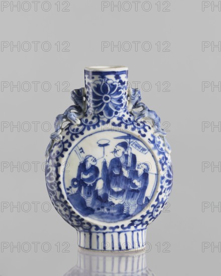 Bian hu moon pilgrim bottle, 17th century China, blue and white porcelain vessel with figurative scenes of circus performers, floral tendril and plant ornaments; height 15 cm, diameter 3.5 cm., A round porcelain vessel with a short cylindrical neck and a flat base, decorated in blue and white. The front shows a circular scene painted in blue featuring a group of figures standing on a patterned ground, surrounded by a scrolling floral border. The neck and upper rim are patterned with stylized floral motifs, and the shoulders have molded, ribbon-like handles on either side. The lower body has vertical stripe decoration near the base and additional scrolling floral ornament around the circumference. The visible colors are white and shades of blue, set against a neutral gray background.