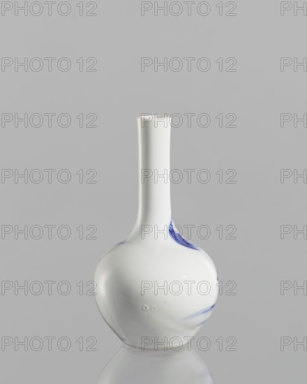 Vase—bottle, ; blue-and-white porcelain with figural scenes and landscape motifs; Chinese; Kangxi period 1662–1722; vessel; height 12 cm., A smooth, glossy white ceramic vase with a long narrow neck and a round bulbous base sits centered against a pale gray background, with a few small blue brushstroke marks on one side and subtle reflections and highlights on its curved surface.