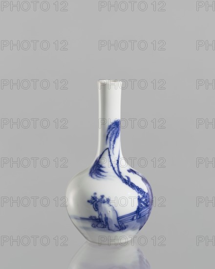 Vase-bottle, blue and white porcelain, figural scenes and landscape motifs; Chinese, Kangxi period 1662–1722; vessel, height 12 cm., A white porcelain bottle-shaped vase with a long narrow neck and a bulbous base stands against a plain gray background, decorated with blue painted scenes including a solitary figure near a low fence, stylized trees with drooping branches, and flowing landscape motifs, the vase casting a subtle reflection on the glossy surface below; visible colors include white, blue, gray, and a hint of reflective sheen.