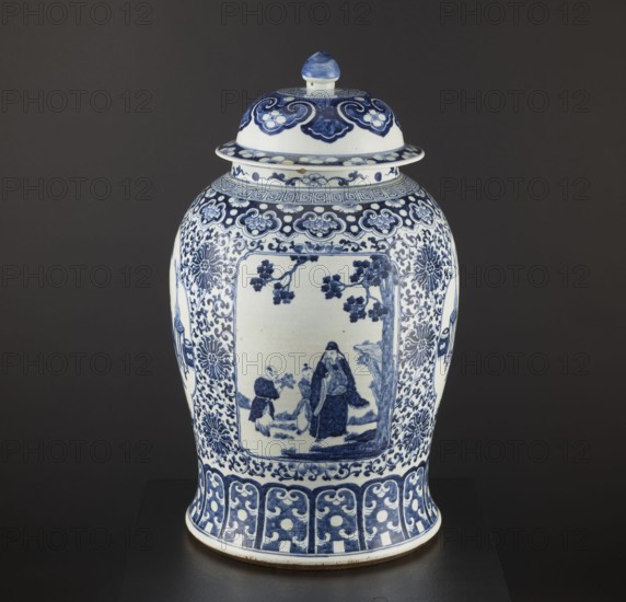 Pot with cover, resource pots, blue-and-white porcelain, Chinese art, plant motifs and mountain landscapes, decorative vessel, ceramics, Qing style, Qing 1644–1911 and Ming 1368–1644 associations, possibly 1st half of the 17th century, China, height 60 cm, diameter 36 cm., A lidded ceramic jar with a rounded body and domed lid sits against a dark background; the jar is predominantly white with extensive blue painted decoration, including floral and cloud-like motifs around the shoulder and a framed rectangular scene on the front showing human figures and tree branches; the lower body features a band of repeating scroll and dot patterns and the lid has complementary blue ornamental designs and a blue-tipped finial.