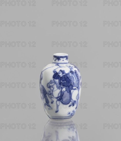 Flask - snuffbox, Chinese, blue-and-white porcelain, figurative scenes of hunting with bows, horses, riders, and blowpipes; 18th–19th century, China; vessel, height 6.5 cm, A small white ceramic vessel with blue painted designs stands upright on a reflective surface, showing a group of human figures and a horse rendered in blue on its rounded body, with decorative blue motifs near the narrow neck and base; the background and surface are gray, and the reflection of the vessel appears below it.