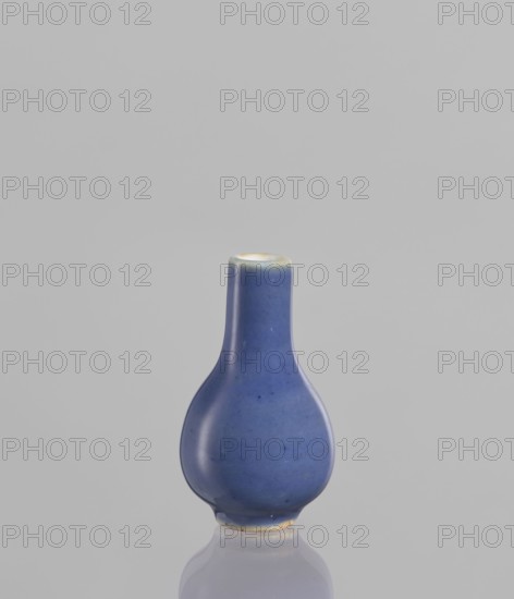 Bottle, Chinese, Chinese art, ceramics, poudre bleu, 19th century, China, vessel, height 5.3 cm, A small, bulbous ceramic vessel with a narrow neck and rounded body sits upright against a plain background; the glaze is a smooth deep blue with subtle variations and a few small darker speckles, the rim and base show a thin band of pale off-white or cream, and the surface casts a soft reflection on the glossy surface beneath it.