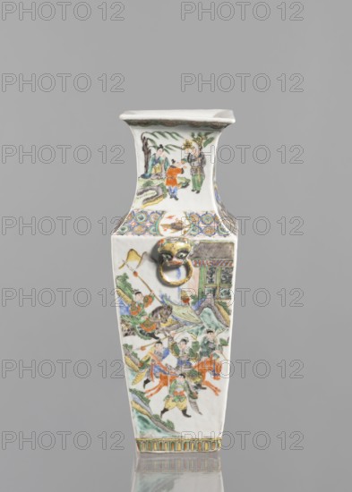 Vase, Chinese, 18th century, ceramics, colored porcelain, figurative scenes depicting battles and genre scenes, vessel, height 31.0 cm, width 11.0 cm., The image shows a tall, narrow vase with a squared, flared neck and a wider base, decorated with painted human figures and scenes. The vase surface features a group of people in traditional dress engaged in various activities, with some figures on horseback and others walking or standing, accompanied by stylized landscape elements such as rocks, trees, and a building facade. A decorative band of patterned motifs wraps around the shoulder above a small sculpted animal-head ring attached to the body. Colors visible include white, green, red, orange, blue, yellow, brown, and black. The background behind the vase is a plain gray.