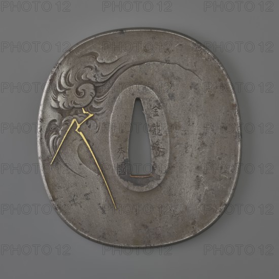 Crossguard tsuba by Kawarabayashi Hidekuni 1825–1891. Rectangular tsuba with rounded corners nadegaku gata and a slightly raised, rounded edge of the uchi nkaeshi mimi type. Decorated with a dragon with a pearl among clouds with lightning, executed in painterly engraving imitating ink painting. Details inlaid with gold and very fine agates. Signed. Hidekuni was a student of Hideoki, a master of the Ôzuki school; he died in 1891. 2nd half of the 19th century Edo/Meiji periods, Japan. Tsuba; height 7.9 cm, width 7.3 cm, depth 0.4 cm., A round metal object with an oval hole near its center sits against a gray background; the metal surface is mostly dark gray with areas of lighter gray and brownish spots, and a carved flowing cloud-like pattern appears on one side. A thin bright gold line in a few segments is inlaid across the carved area, forming angular shapes that contrast with the gray metal. The object shows subtle surface scratches and varied patina, and its edges are slightly irregu...