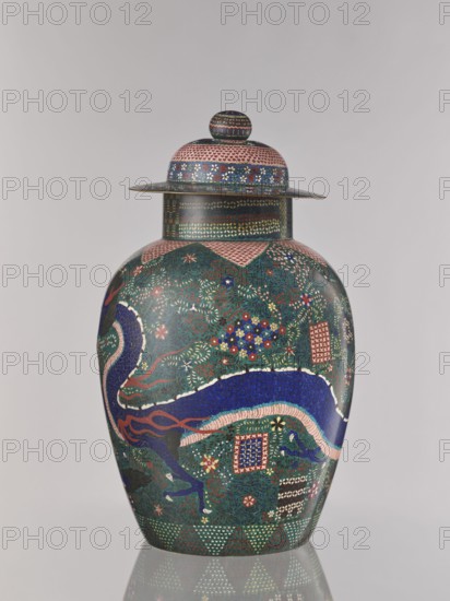 Vase with cover, Japanese art, Japanese culture, dragons, covers, Japanese dragon motif, plant ornament, Meiji 1868–1912, geometric-plant ornament, geometric ornament, Edo 1603–1868, shippo pattern, kikko pattern, asanoha pattern, cloisonné enamel, Man'en 1860–1861, ca. 1860–1870 Man'en 1–Meiji 3, Japan, vessel, height 57.0 cm, A lidded ceramic vase with a rounded body and a domed lid topped by a small knob, featuring intricate painted patterns in colors including dark green, deep blue, pink, red, white, and gold; the surface shows a decorative band around the neck with small geometric motifs, a large sinuous dragon-like figure in deep blue and pink wrapping around the body, scattered floral and starburst motifs in red, white, blue, and gold, and several small square framed patterns in red and blue; the lid and shoulder have repeating dot and floral bands in pink, blue, white, and gold, and the base displays triangular and dot patterns in green, red, and white, all set against a plain ...