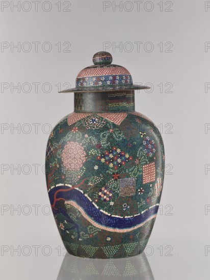 Vase with cover, Japanese, cloisonné enamel, dragons and plant ornament, Japanese dragon motif, geometric-plant ornament combining shippo, kikko, and asanoha patterns, Meiji period ca. 1860–1870; Man'en 1–Meiji 3, Edo 1603–1868 influences, Man'en 1860–1861, vessel, height 57.0 cm, A lidded rounded vessel with a bulbous body and a flat-rimmed lid sits against a plain light gray background; the vessel displays an intricate overall pattern in dark green, deep blue, pink, red, white, yellow, and gold, including floral motifs, small geometric patches, and a sinuous dragon-like form in dark blue with pink and white accents that curves around the lower body; the lid and neck area feature bands of small repeating patterns and dots in pink, blue, green, white, and gold, and the vessel’s surface shows dense, finely detailed decoration with clusters of tiny flowers and leaf-like marks in multiple colors.