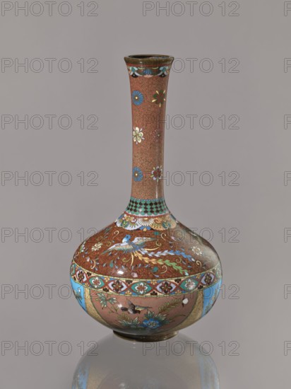 Vase, Japanese art, Japanese culture, plants, butterflies, phoenixes iconography, Meiji 1868–1912, kinseki, hoo phoenix, cloisonné enamel, ca. 1880 Meiji 13, Japan, vessel, height 30.5 cm, diameter 16.0 cm, A tall, narrow-necked vase with a rounded body sits against a plain gray background, decorated with a repeating intricate pattern in brown serving as the base color, and adorned with floral motifs in blue, white, green, red, and yellow. The neck displays small scattered flowers in blue, white, and red on the brown ground, while the shoulder and body feature ornate bands with turquoise and white accents, stylized birds and floral sprays in blue, green, white, and gold, and a lower register showing additional floral and bird motifs framed by turquoise panels. The rim and base show darker brown and metallic tones, and the vase casts a soft reflection on the surface beneath it.