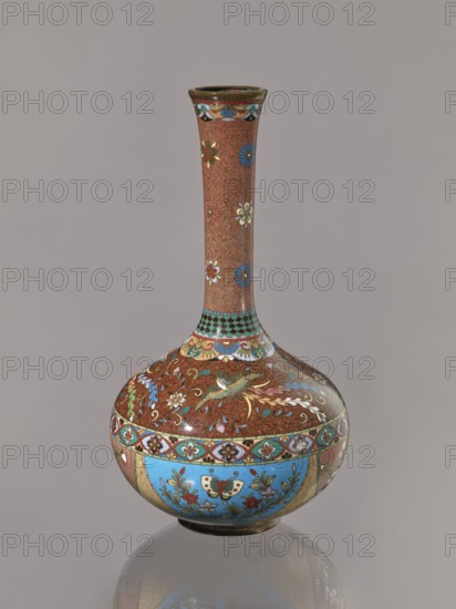 Vase, Japanese, Meiji 1868–1912, ca. 1880 Meiji 13; cloisonné enamel vessel decorated with plants, butterflies, and phoenixes hoo/kinseki; height 30.5 cm, diameter 16.0 cm., A narrow-necked vase with a rounded body sits against a plain gray background, its surface covered in intricate floral and animal motifs in colors including brown, blue, green, white, red, gold, and turquoise; the long slender neck is primarily brown with scattered stylized flowers in blue, white, red, and green and a decorative band near the top in turquoise and gold, while the bulbous lower body features a dense brown background with scrolling foliage and birds highlighted in gold and green, a band of patterned motifs encircling the widest part, and panels of bright blue with floral and butterfly-like designs accented in red, green, white, and gold, the vase resting on a small rounded base that reflects subtly on the surface below.