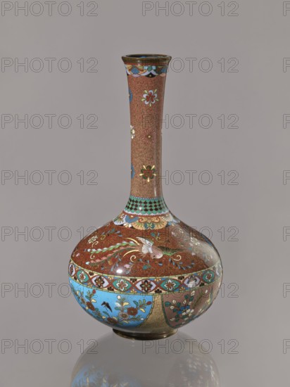 Vase, Japanese art, Japanese culture, plants, butterflies, phoenixes iconography, Meiji 1868–1912, hoo phoenix, cloisonné enamel, ca. 1880 Meiji 13, Japan, vessel, height 30.5 cm, diameter 16.0 cm, A decorative vase with a long narrow neck and rounded body standing on a reflective surface, featuring a predominantly reddish-brown background with intricate floral and swirl patterns, a few flower motifs in white, blue, green, and gold along the neck, a band near the shoulder with alternating turquoise and gold scalloped shapes, and the bulbous lower section decorated with panels of bright blue and muted teal containing floral sprays and birds in colors including white, green, red, and gold, with additional accents of black and brown and a glossy finish.