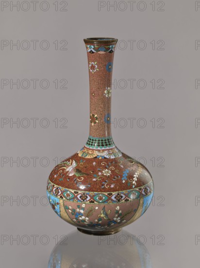 Vase, Japanese art, Japanese culture, plants, butterflies, phoenixes iconography, Meiji 1868–1912, hoo phoenix, cloisonné enamel, ca. 1880 Meiji 13, Japan, vessel, height 30.5 cm, diameter 16.0 cm, A tall, narrow-necked vase with a bulbous base sits against a plain gray background; its surface shows intricate floral and bird motifs in colors including brown, blue, green, white, gold, and red, with a patterned band near the widest part and decorative scalloped and geometric designs around the neck and shoulder, and a reflective base that mirrors the vase's lower portion.