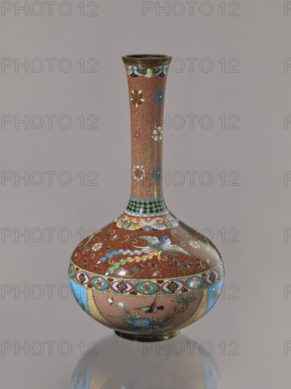 Vase, gift, Japanese art, Japanese culture, plants, butterflies, phoenixes iconography, Meiji 1868–1912, hoo phoenix, cloisonné enamel, ca. 1880 Meiji 13, Japan, vessel, height 30.5 cm, diameter 16.0 cm, A tall narrow-necked vase with a bulbous base sits against a plain neutral background; the vase shows a dominant reddish-brown ground covered with delicate swirling patterns and scattered floral motifs in white, blue, green, and yellow on the neck, a band of turquoise and black scale-like decoration at the shoulder, and richly decorated panels on the body featuring stylized birds, flowers, and foliage in blue, turquoise, green, yellow, white, and gold with accents of black, all outlined in dark lines, and a reflective surface creating a subtle reflection of the vase on the surface beneath it.