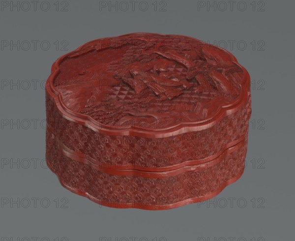 Box with a lid, Chinese, Qing dynasty 1644–1911, 2nd half of the 18th century. Lacquered box with figurative scenes of sages, scholars and servants amid landscape motifs pine trees, rocks, rosettes, kikko tortoiseshell pattern, geometric ornament. Vessel. Height 11.0 cm; width 4.8 cm., The image shows a carved, round box with a scalloped edge, rendered in a deep red color against a gray background; the box has intricate raised floral and geometric patterns on its sides and a detailed relief scene on its lid, with visible texture and highlights in red and darker red tones.