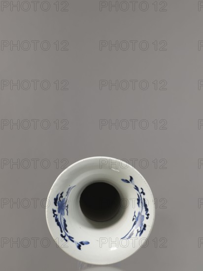 Vase, ca. 1690–1730 Genroku–Kyoho periods, Japan, Arita; blue-and-white porcelain vessel, height 39.0 cm, dia. 20.3 cm; decorated with hares/rabbits, peonies, lotuses, phoenix hoo, kachoga flowers-and-birds iconography. One of four elements of a set., A top-down view of a white ceramic vessel with a wide rim and a dark hollow interior, decorated on the inner rim with a few blue floral brushstroke motifs; the background is a smooth grey.